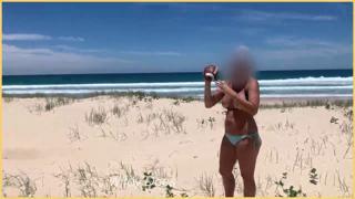 Beachside babe flaunts assets sans bikini top, jugs bouncing in wind